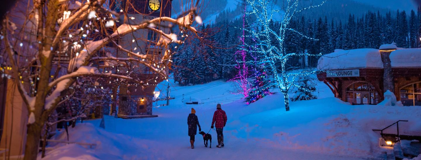 Winter village, couple walking dog, holiday lights